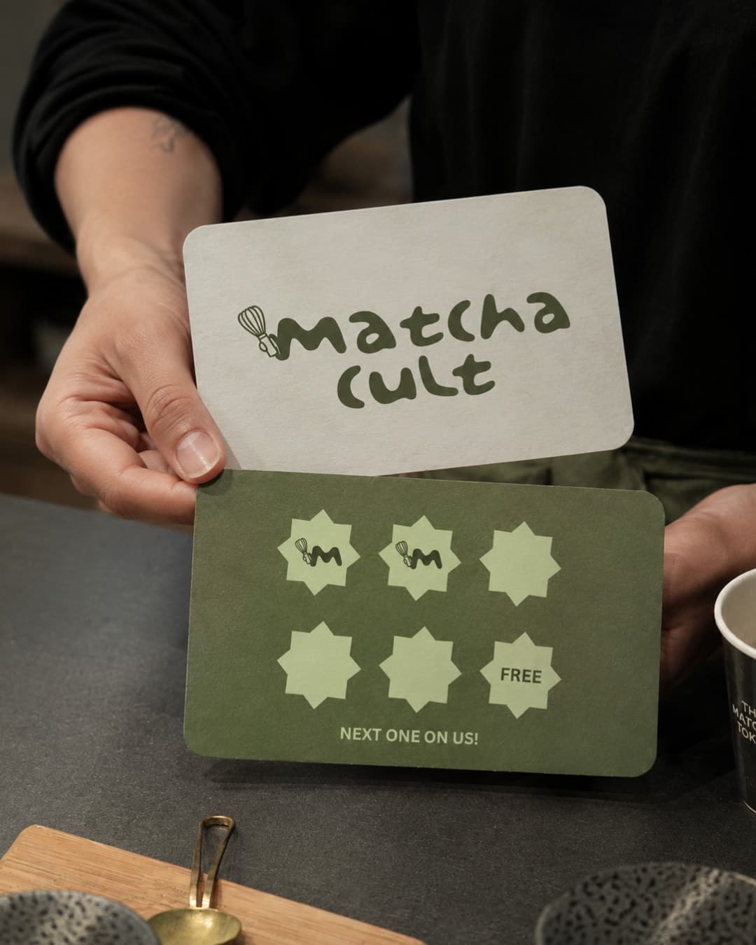 Hands holding the Matcha Cult loyalty card